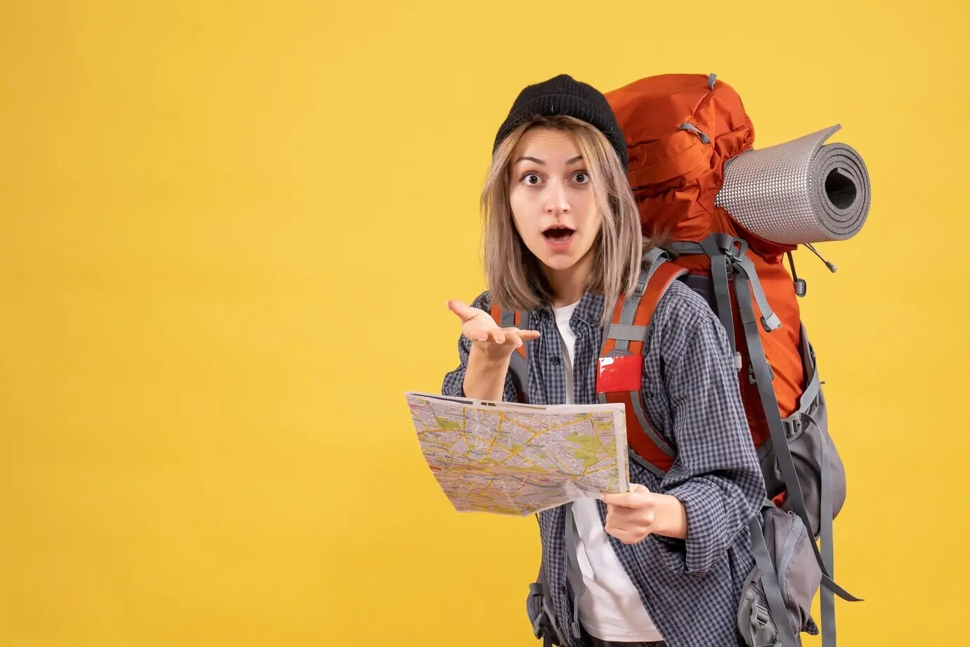 A perplexed female traveler with a backpack holding a map.